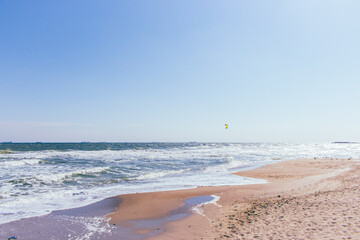 Kite surfing on beach with trade ships on horizon. Active lifestyle. Extreme sports concept. Man in...