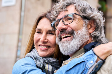 Close up Caucasian smiling pensioners love couple standing hugging together outdoors. Happy...