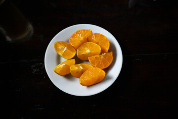 platter of orange citric limes cut in multiple slices ready to be juiced