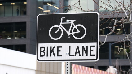 Close up of bike lane sign post with a bicycle in black and white in American city