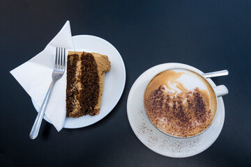 A cup of cappuccino and a slice of chocolate cake served at a Greenwich Market cafe.