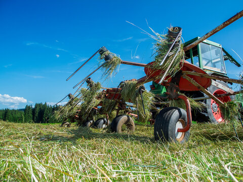 Hay tedder on a mown meadow