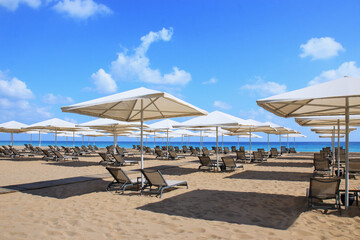 Beautiful tropical scenery. Sun beds, loungers, umbrella. Sea. Resort hotel. Rows of folded beach...