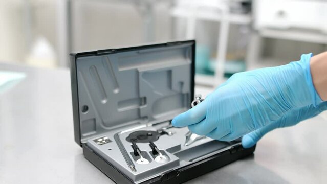 Doctor ophthalmologist preparing ophthalmoscope for examining the eyes in clinic. Funduscopy can diagnose various eye conditions