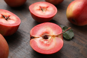 Tasty apples with red pulp on wooden table, closeup