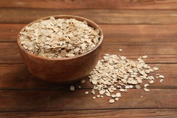 Bowl with oatmeal on wooden table, closeup