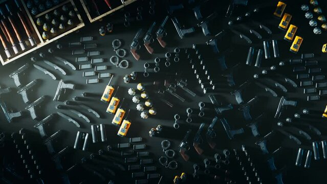 Overhead view of a firearms and ammunition collection on a dark