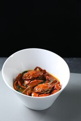 Delicious boiled crabs with sauce on table, space for text