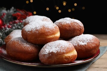 Delicious sweet buns on table against black background with blurred lights, closeup