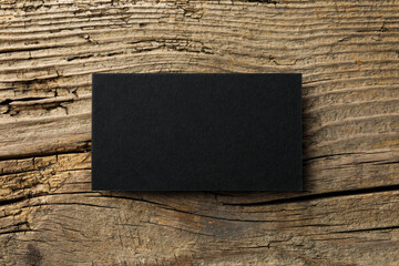 Empty black business card on wooden background, top view. Mockup for design