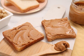 Toasts with tasty nut butter on white table