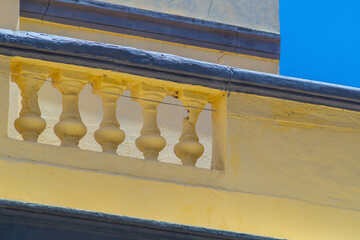 Wall fencing with decorative concrete balusters in Greek, antique style. Combination of yellow and...