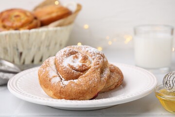 Obraz na płótnie Canvas Delicious roll with sugar powder on white tiled table, closeup. Sweet bun