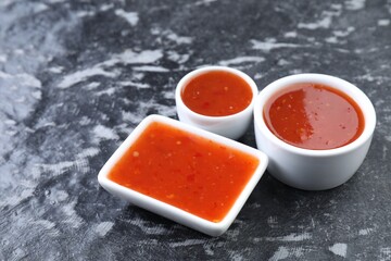 Spicy chili sauce on black textured table