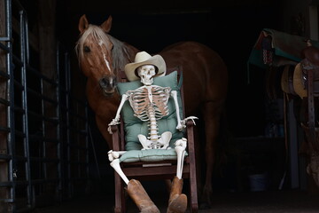 " Wenn es mal länger dauert". Skelett mit Cowboyhut und Stiefel sitzt vor Pferd im Schaukelstuhl
