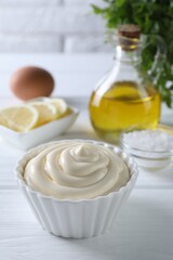 Obraz na płótnie Canvas Fresh mayonnaise sauce in bowl on white wooden table