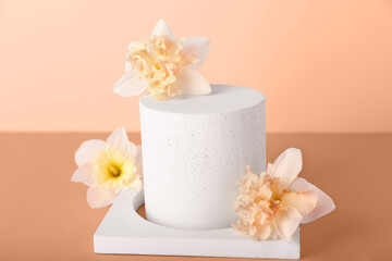 Decorative plaster podiums with narcissus flowers on nude background
