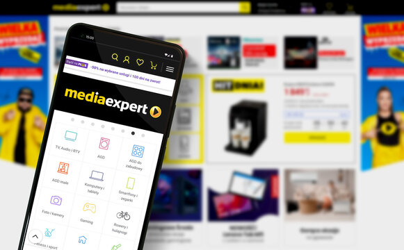 Media Expert Mediaexpert shop mobile website on smartphone and online shop on desktop screen in background - Warsaw, Poland 10.01.2024