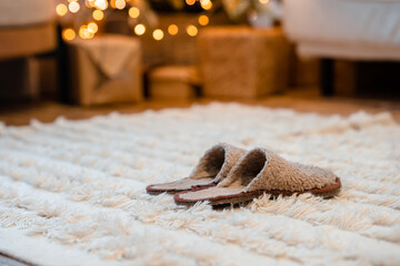 New Year's decor in the house and fur slippers in front of the Christmas tree