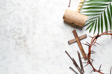 Crown of thorns with wooden cross, nails, mallet and palm leaf on white grunge background. Good...