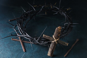 Fototapeta na wymiar Wooden cross, crown of thorns and nails on dark background. Good Friday concept