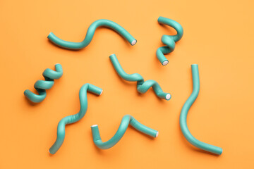 Hair curlers on orange background