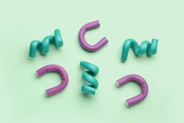 Hair curlers on green background