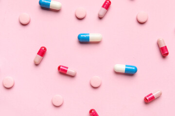 Different pills on pink background