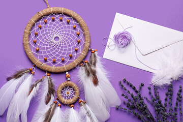 Dream catcher with envelope and lavender flowers on purple background
