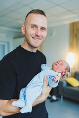 Newborn baby boy in his father's arms, lying on his arms close-up top view. A man is holding a small child. Healthy Lifestyle. Paternity