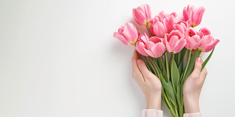 Close-up of Hands Grasping a Bunch of Pink Tulips Against a White Background