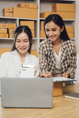 Two asian women with startup small business entrepreneur freelance working at home. checking product order. Online woman sellers working for e-