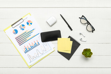 Composition with eyeglasses, documents, plant and paper sheets on white wooden background