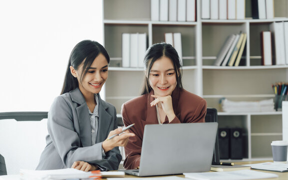 Group of young asian businesswoman working and brainstorming in workshop and analyzing marketing reports startup project infographics in the office.