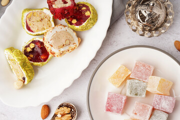 Plates with tasty Turkish delight on light background, closeup