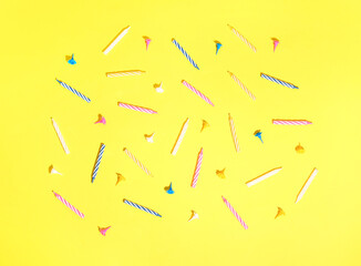Colorful birthday candles on yellow background