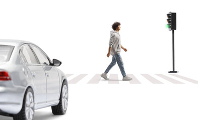 Full length portrait of a tall guy crossing a street at a pedestrian crossing