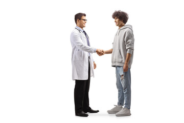 Full length profile shot of a male doctor shaking hands with a young man