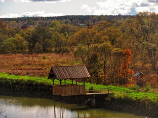 Old public wooden gazebo for relaxing over the pond	