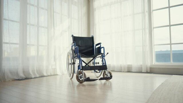 Empty wheelchair in clinic lobby. Wheelchair used for physical recovery service on health care insurance, paralyzed injured patients. Healthcare, medicine, medical objects helping to live concept.
