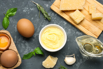 Composition with bowl of Caesar sauce and ingredients on grunge table