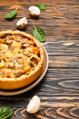Mushroom pie with spinach leaves and champignons on wooden table