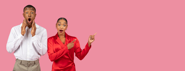 Shocked black man and surprised woman pointing, wide pink background
