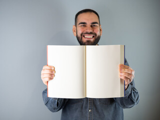 young happy man showing a white paper book Copy space
