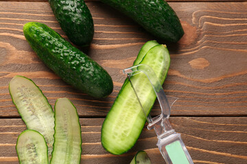 Fresh cucumbers and cut slices on wooden background