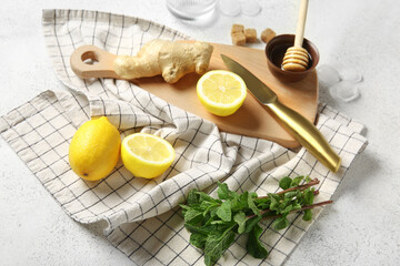 Wooden board with ingredients for preparing lemonade on grunge white background