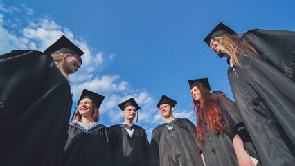 Obraz premium Graduating students stand in a semicircle on a sunny summer afternoon.