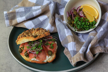 Gourmet Smoked Salmon Bagel With Fresh Herbs and Capers on a Stylish Ceramic Plate