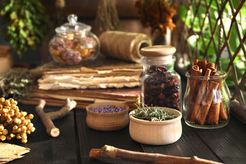 Different dry herbs and flowers on black wooden table indoors