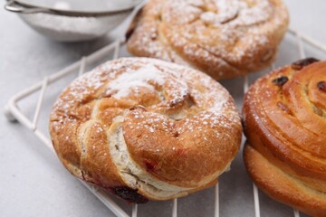 Obraz na płótnie Canvas Different delicious rolls on light table, closeup. Sweet buns
